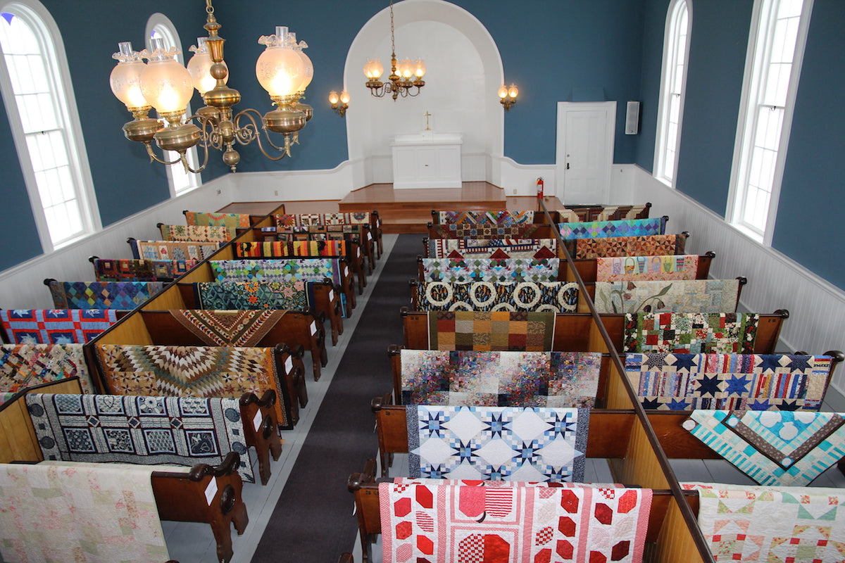 Quilting in Historic Port Gamble.  Quilts over the pews in St. Paul's Church in Port Gamble, Washington